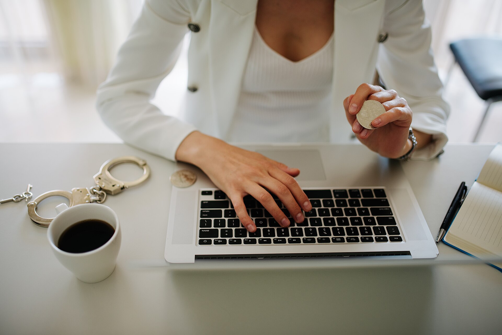 A professional working on a laptop with a coffee at a desk